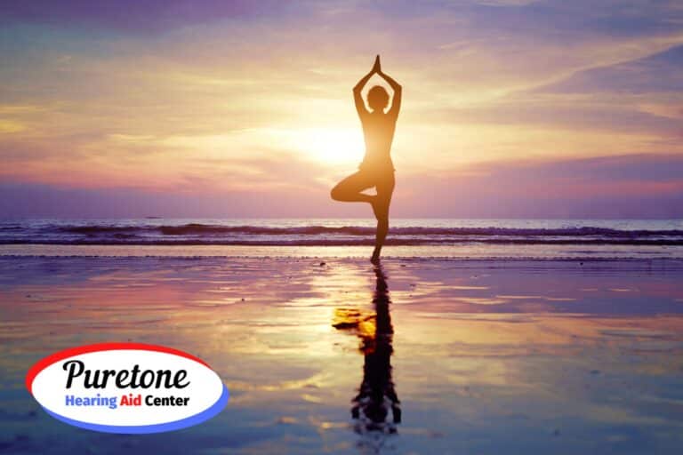 Woman doing yoga on the beach at sunset