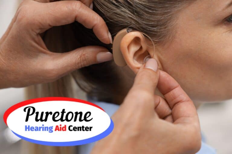audiologist putting a hearing aid on a woman's ear